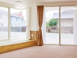 大きな窓が付いた明るい共有スペース。左側には畳の小上がりがある。