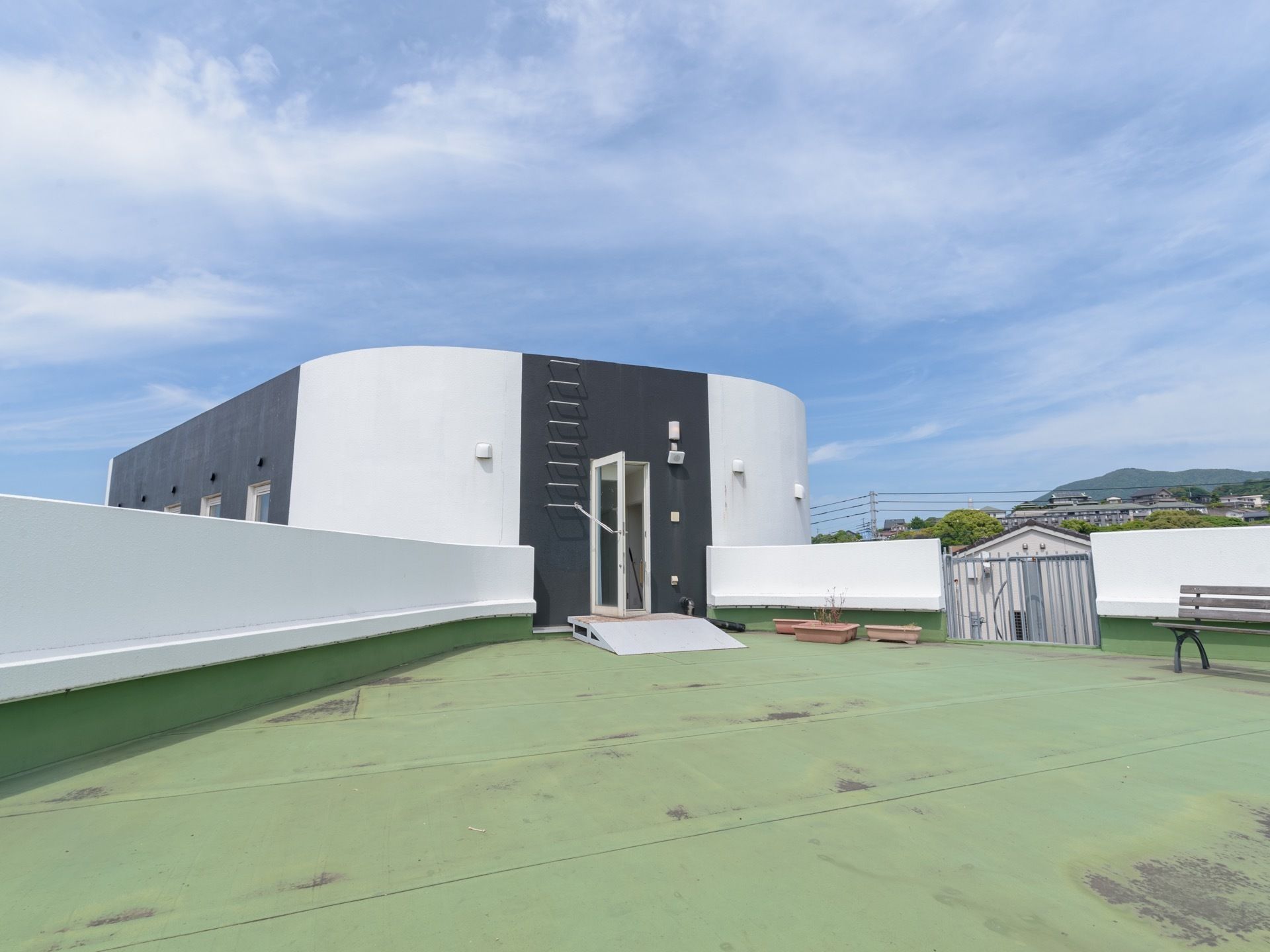 ３階建の施設の最上階には、屋上が設けられている。出入口にはスロープが設置されており、壁際にベンチが置かれている。