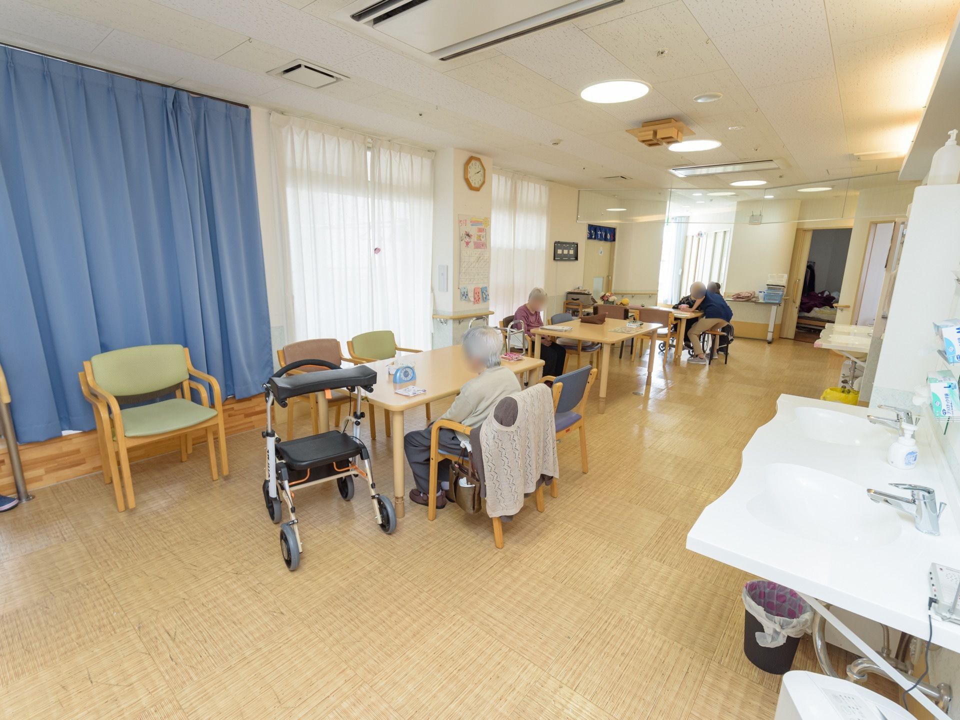 広々としたダイニングには、車椅子対応洗面台や冷暖房が完備されている。ダイニングテーブルと椅子が用意されている。