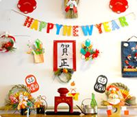 お屠蘇セットや鏡餅などが飾られていて、壁には賀正と書かれた紙やHAPPYNEWYEARのガーランドがある。