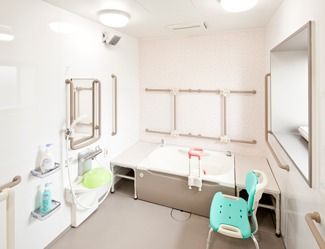 壁に手すりがあるタイプの高齢者用浴室の様子。シャワーチェアがあるのが分かる