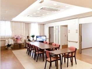 ユニットごとにあるリビングの様子。木製の椅子と長い机が並んでいるスペース