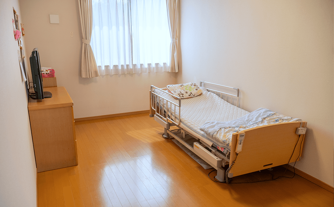 窓際のベッドと机の部屋