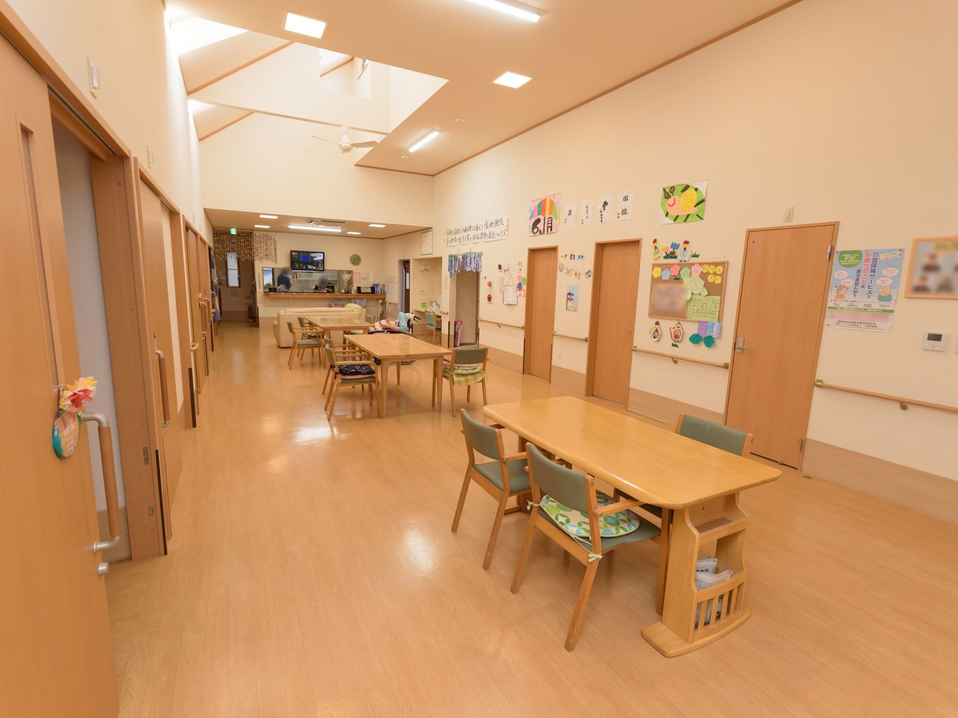 明るく開放的な食堂である。ダイニングテーブルと椅子が用意されており、対面式キッチンが併設されている。居室が両サイドに設けられている。