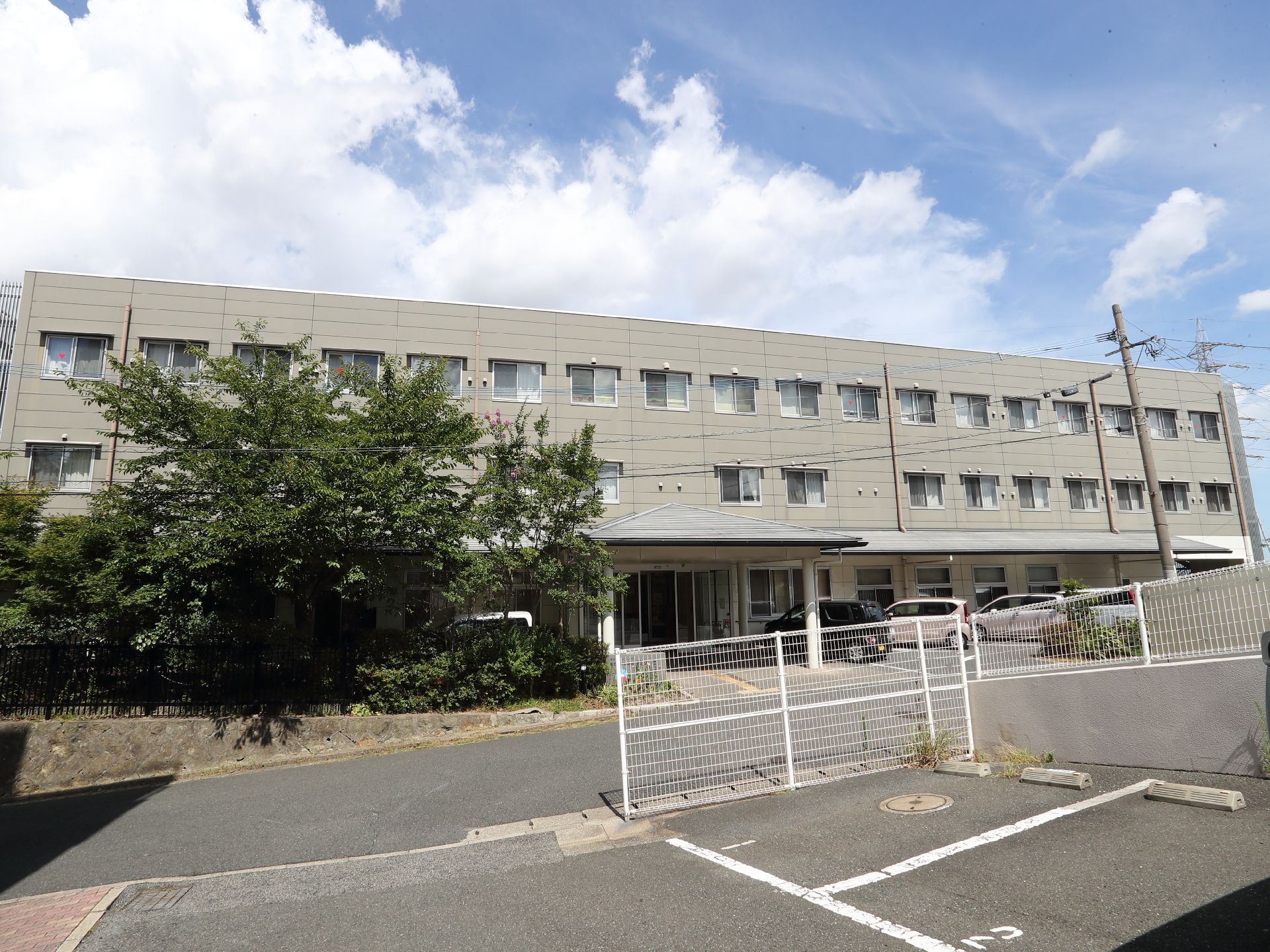 灰色の外観で３階建ての建物