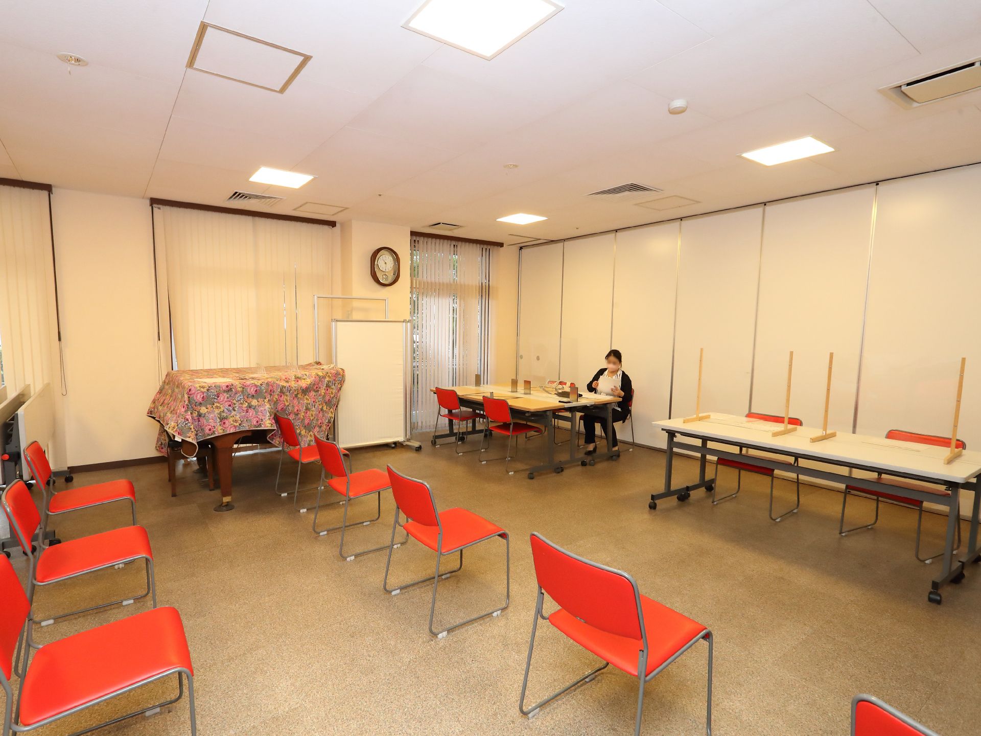 赤い椅子が並んだ白い壁の広間