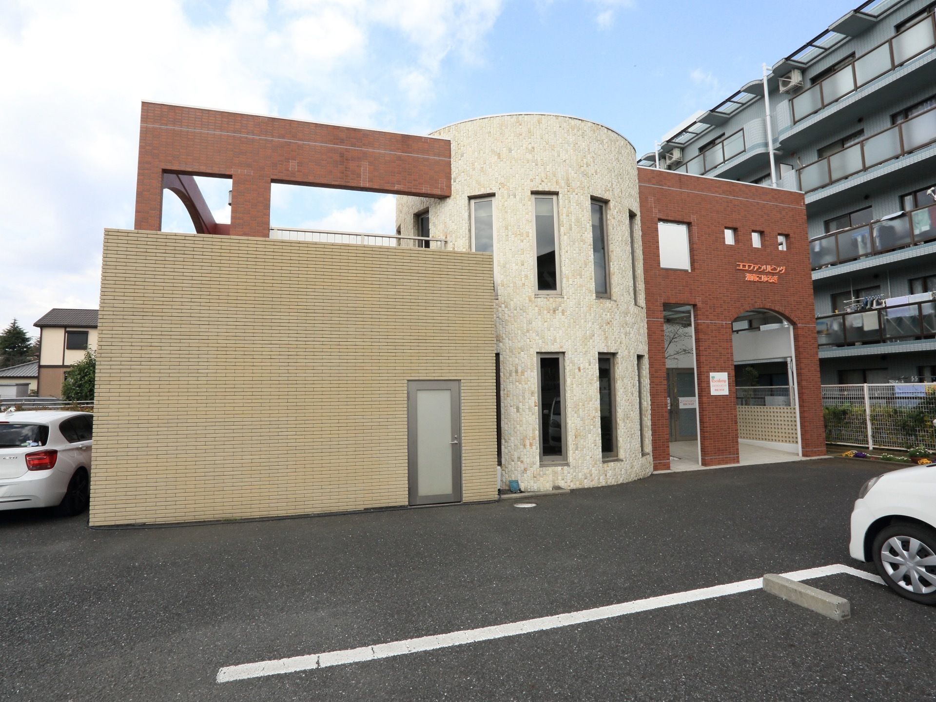 ２階建てでデザイン性のある建物である。外から見えないように壁が造られている。敷地には駐車場も完備している。