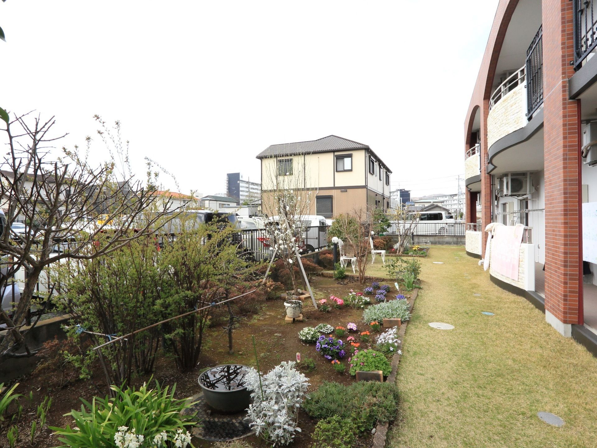 居室の前には庭が造られている。芝が敷かれ、四季の花、木が植えられており、奥にはガーデンチェアも置かれている。