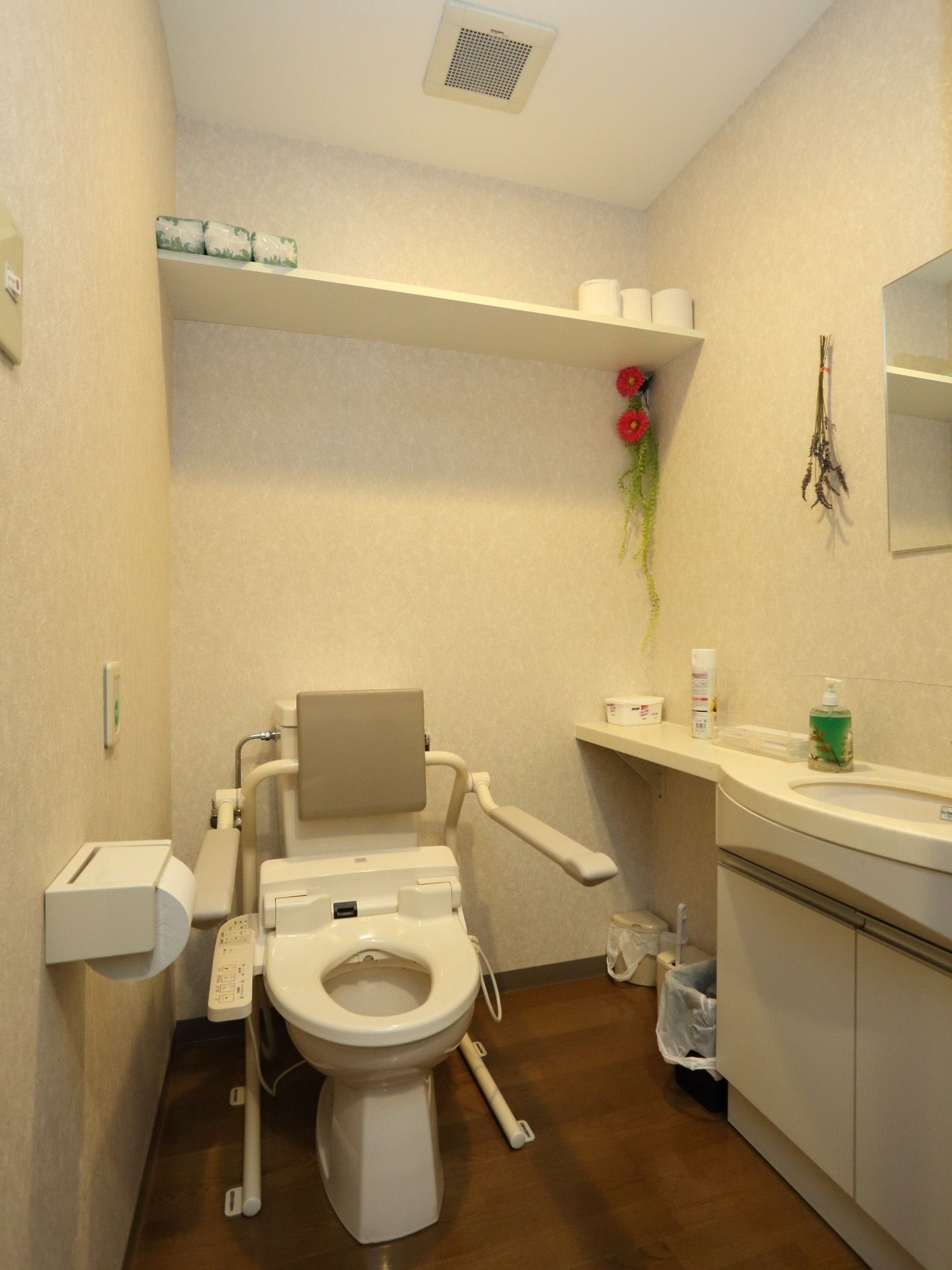 清潔感のあるトイレになっている。便器の両側に可動式のひじ掛けがあり安全に利用することができる。手洗い場も設けられている。