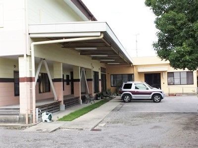 駐車場スペースがある施設の敷地内。学校のような建物とその中庭の様子