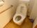 トイレの中は小花柄の内装で、明るく親しみやすい雰囲気。便器のそばには、安全のために手すりが取り付けてある。