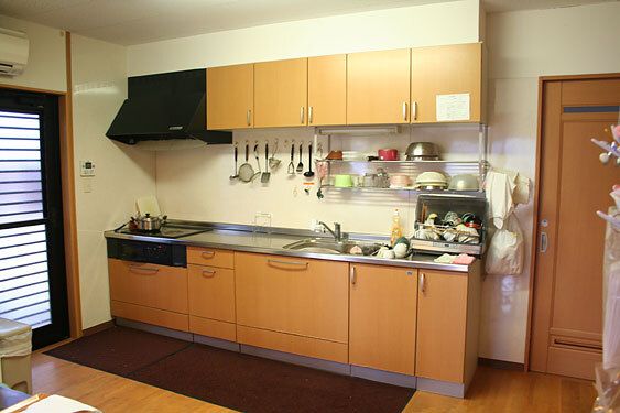 ブラウン系のキッチンはIHクッキングヒーターが設置され、作業台も広い。調理器具もそろっている。
