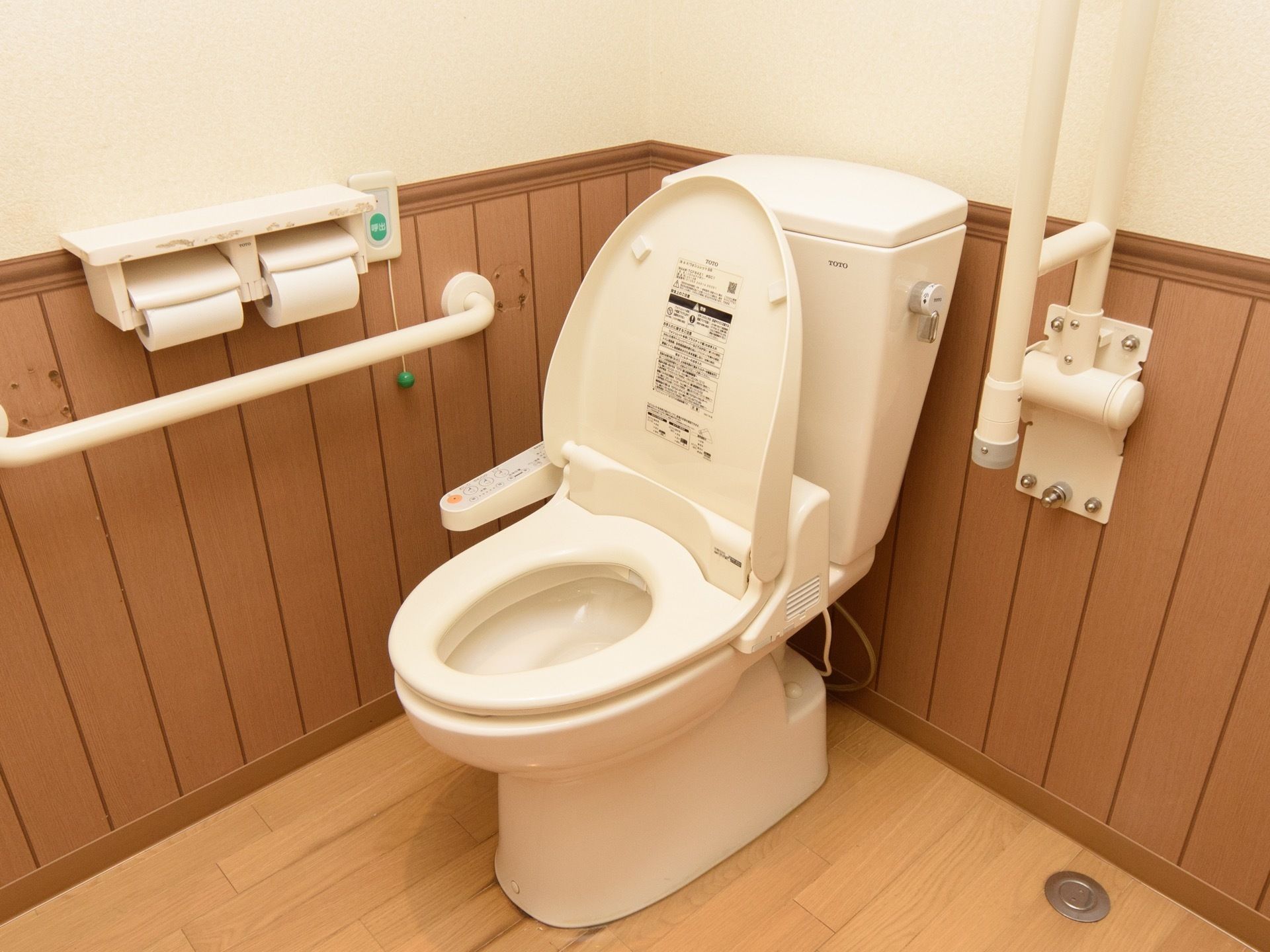 温水洗浄便座が１台設置された個室トイレで、壁にナースコールがある。ナースコールの左側にトイレットペーパーホルダーがある。