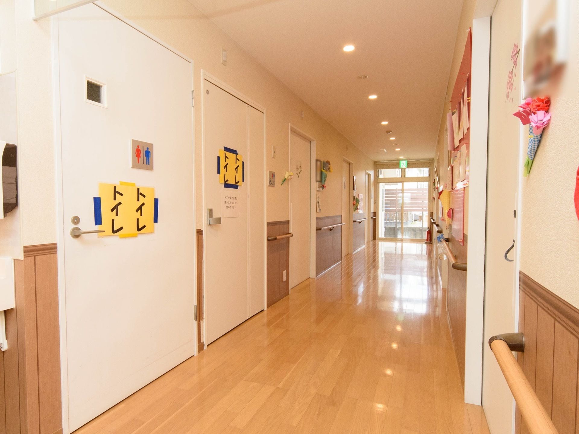 幅広の通路には手すりが設置されている。トイレの間口は通常より広い設計である。壁面に掲示板が設けてある。