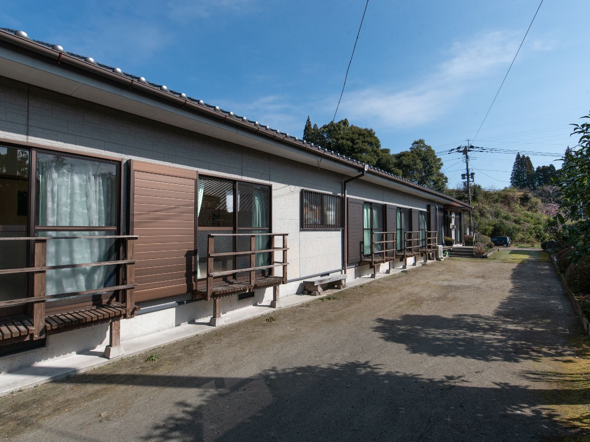 １階のみの横に長い平屋建ての建物である。居室の窓が並び、窓の前に柵が取りつけられている。施設の前は砂利が広がっている。