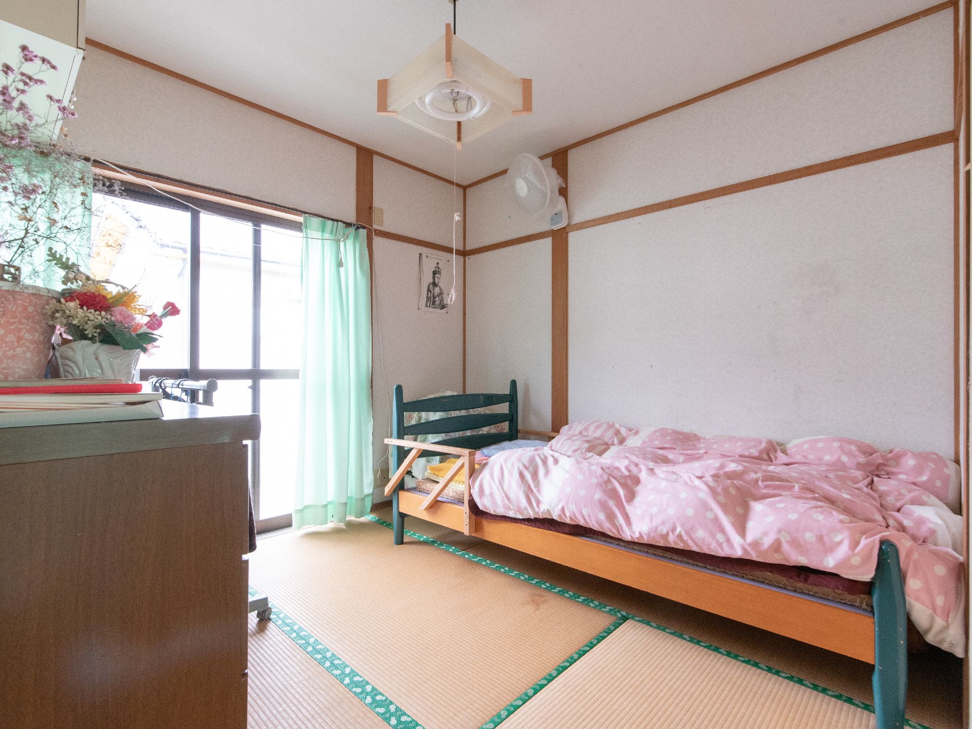 畳が敷かれた和室タイプの和室である。壁際に手すりのついたベッドがあり、ピンクの掛布団が敷かれている。