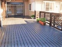 広めのウッドデッキの写真。奥のほうに施設内へつながる窓がある様子