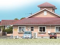 ２階建ての住居のような建物の外観写真。自然に囲まれた環境が写っている写真