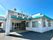 笑顔でこちらを向いている施設のスタッフと車いすに乗っている高齢者の様子。施設で写された写真