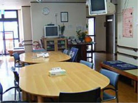 だ円形のテーブルが設置され畳面のベンチが置かれた共有スペース