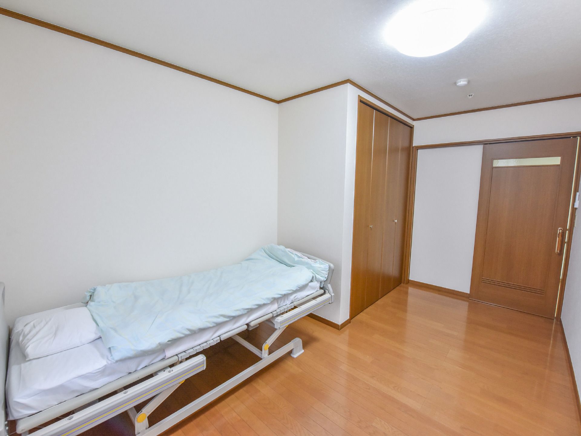 居室ドアはスライド式である。クローゼットがある。バリアフリーである。天井には煙探知機が設置されている。