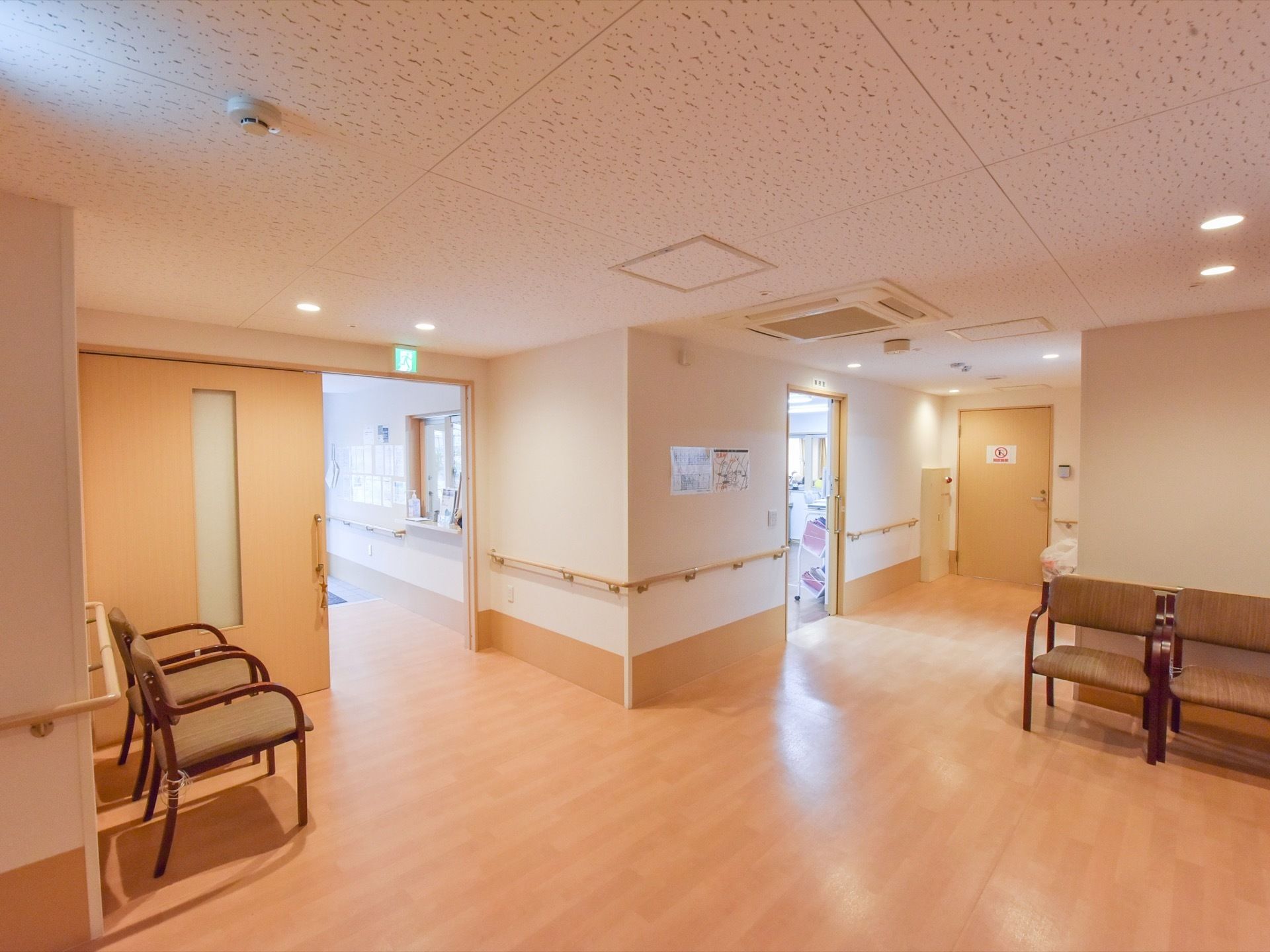 廊下はゆったりとしたスペースがあり、壁際には椅子が4脚並べられている。どの部屋も大きな引戸が取りつけられている。