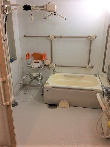 介護入浴用のイスがある浴室。壁にはバーが取り付けられている。