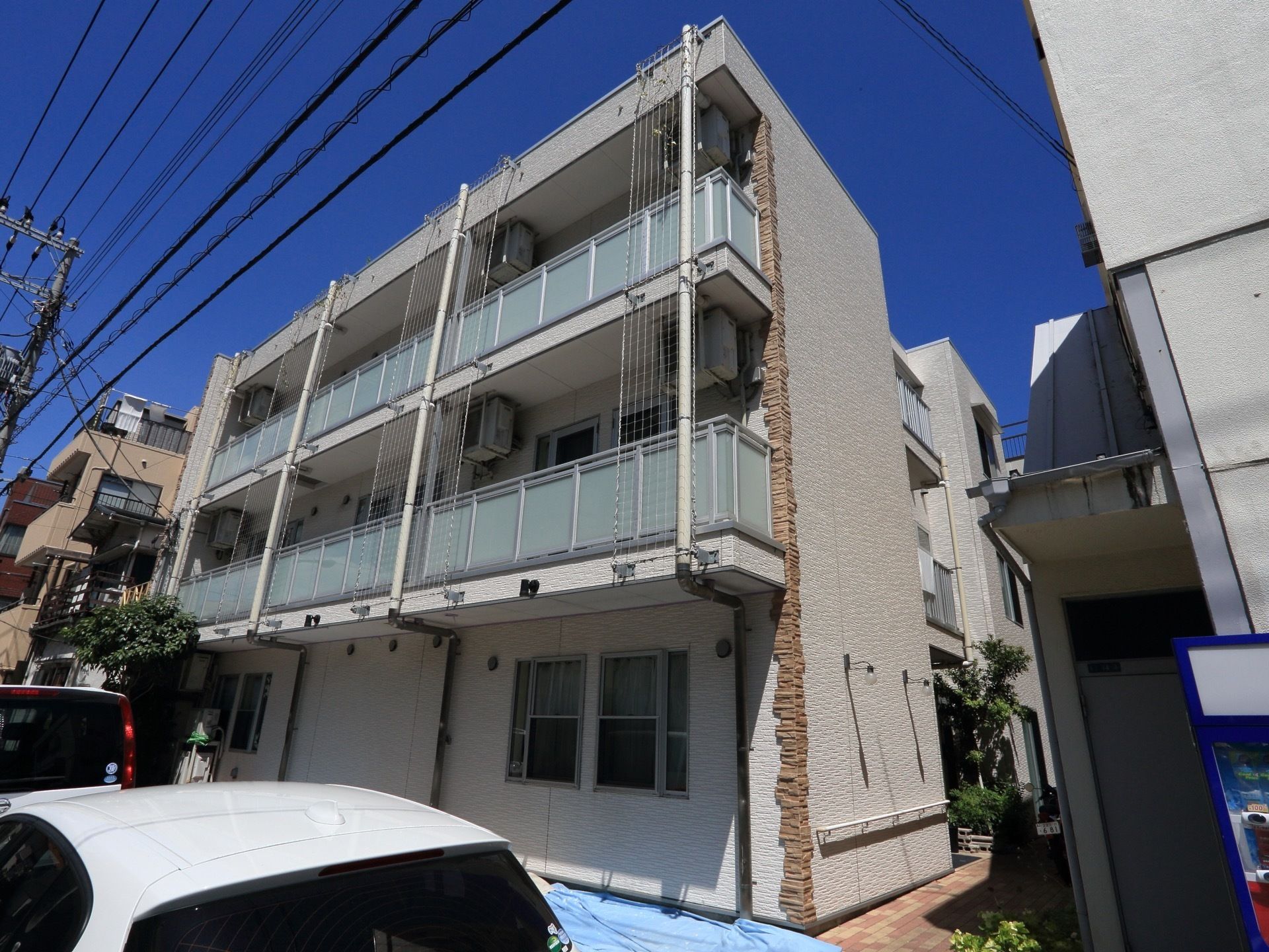 落ち着いた色調の３階建ての施設である。居室にはすりガラス板で目隠しされたバルコニーが設置されている。玄関は奥まった位置にある。