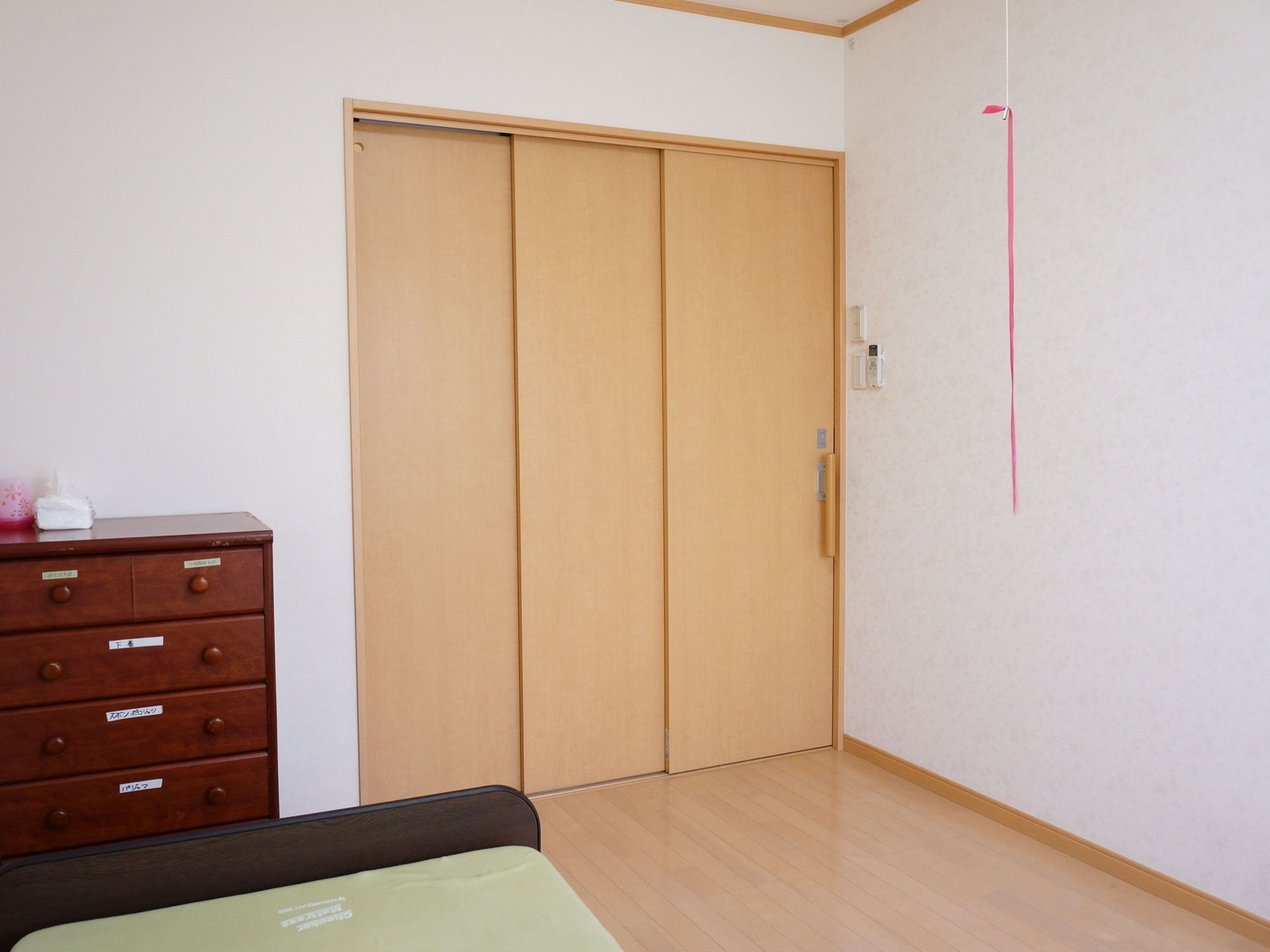 居室の入り口は、スライド式のドアになっている。壁には照明器具のスイッチがあり、リモコンを備え付けている。