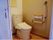引き戸式のトイレで、出入りもスムーズ。温水洗浄便座で手すりも付いているので快適に使用する事ができる。