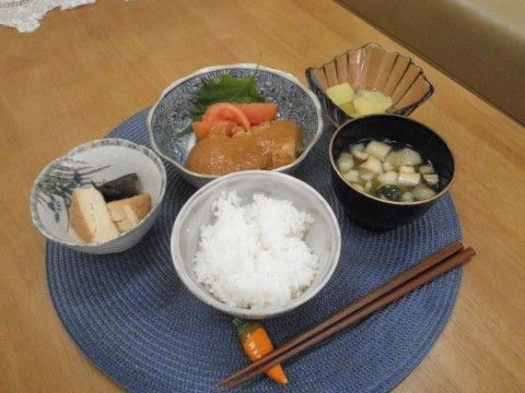 円形のランチョンマットの上に料理が並べられている。可愛らしい人参の箸置きが置かれている。デザート付きのメニューとなっている。