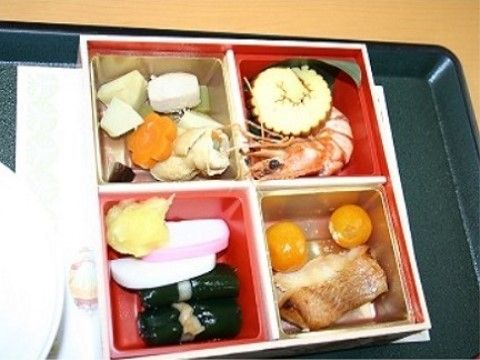 お弁当の中身はカレイの煮つけ、キンカンの甘露煮、伊達巻、エビの酒蒸し、野菜の煮物、昆布巻、カマボコなどである。