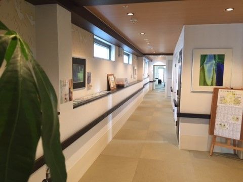 白い壁に濃いブラウン系の手すりが設置された見通しの良い畳敷きの廊下