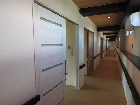 居室につながる扉が並ぶ廊下である。白木が使われた扉と、木目調の扉の２種類があり、どれも引き戸である。