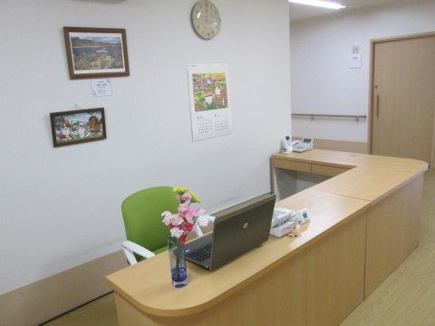 明るい木目調のコーナーカウンターを設置して設けた受付