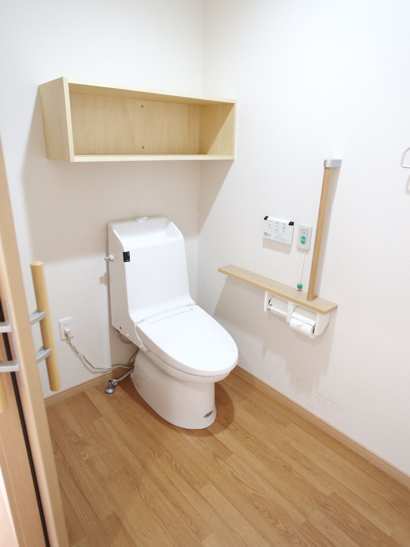 トイレのドアはスライド式なため、出入りが楽に行える。ウォッシュレットなので、清潔に保つこともできる。手摺もあって安心。