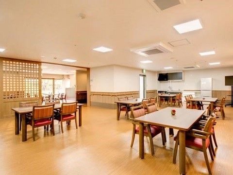 壁には手すりが取り付けられている。空間の一角にはキッチンがあり、白い冷蔵庫が置かれている。その隣にはテレビがある。