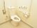 トイレにはお尻の洗浄機能がついた洋式便器を設置している。また壁には緊急時の呼び出しボタンがあり、手すりが取り付けられている。