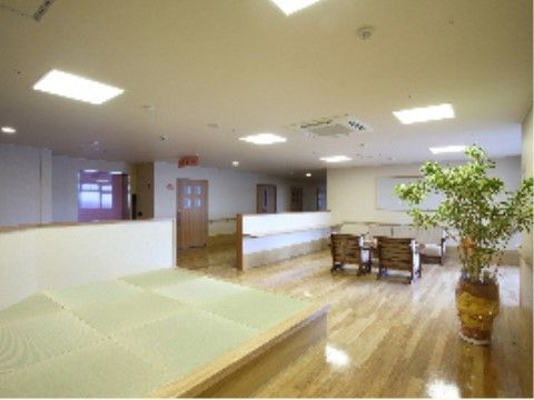 通路との仕切りは腰の高さの壁になっており、開放感がある。フローリングの広い空間に畳のスペースが設けられている。