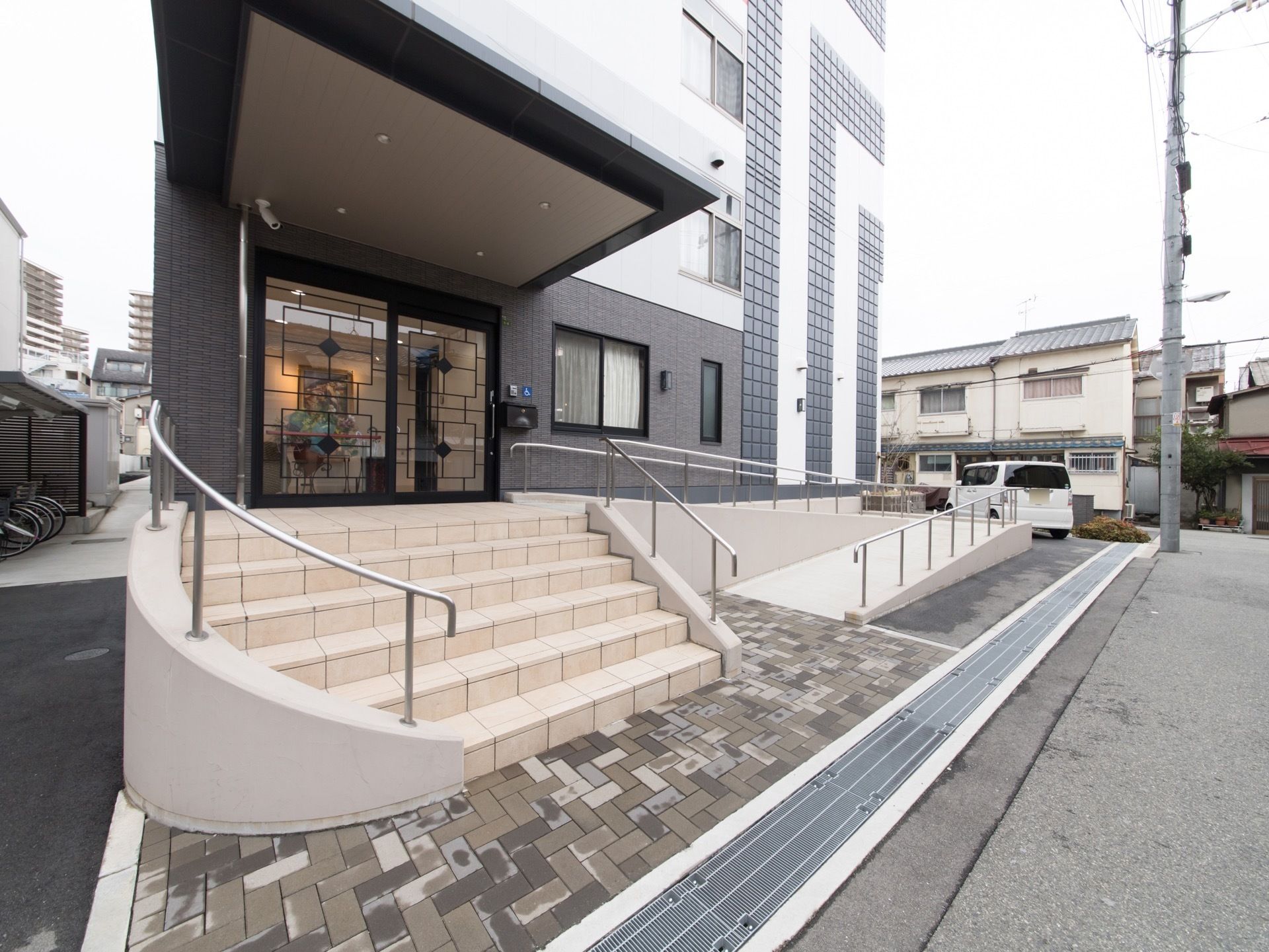 外側から見た玄関口。公道に接しており、正面には階段、右側には車椅子用のスロープを設置しているので、状況に合わせて利用できる。