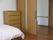 部屋の中から見た写真で、手前にベッドとタンスが置いてある。ドアは引き戸になっており、段差のないバリアフリー設計である。
