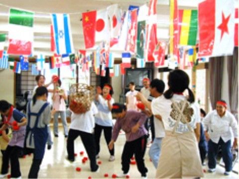 施設内で飾り付けられた国旗の下、玉入れを楽しむ入居者たち