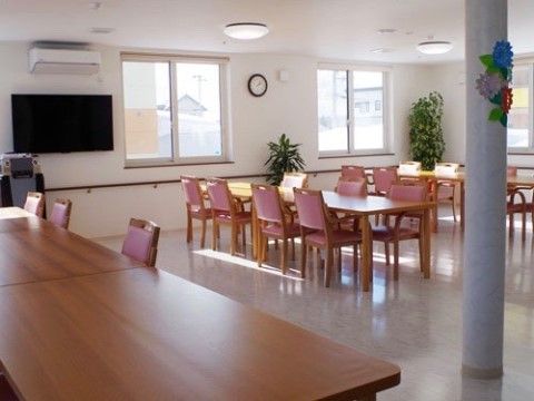 白を基調とした明るく開放的な食堂である。柱には折り紙で造られた手作りの花の装飾がされており、観葉植物が置かれている。