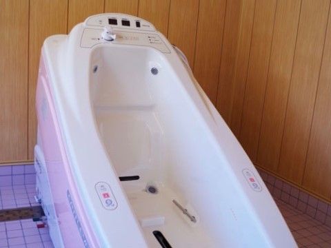 シンプルな操作パネルが取り付けられた浴槽。外側はピンク色、内側は白色を基調とした優しい色合いとなっている。