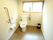 トイレには窓が設置されている。洋式便器の横には固定式と可動式の手すりが取り付けられている。ゴミ箱もある。