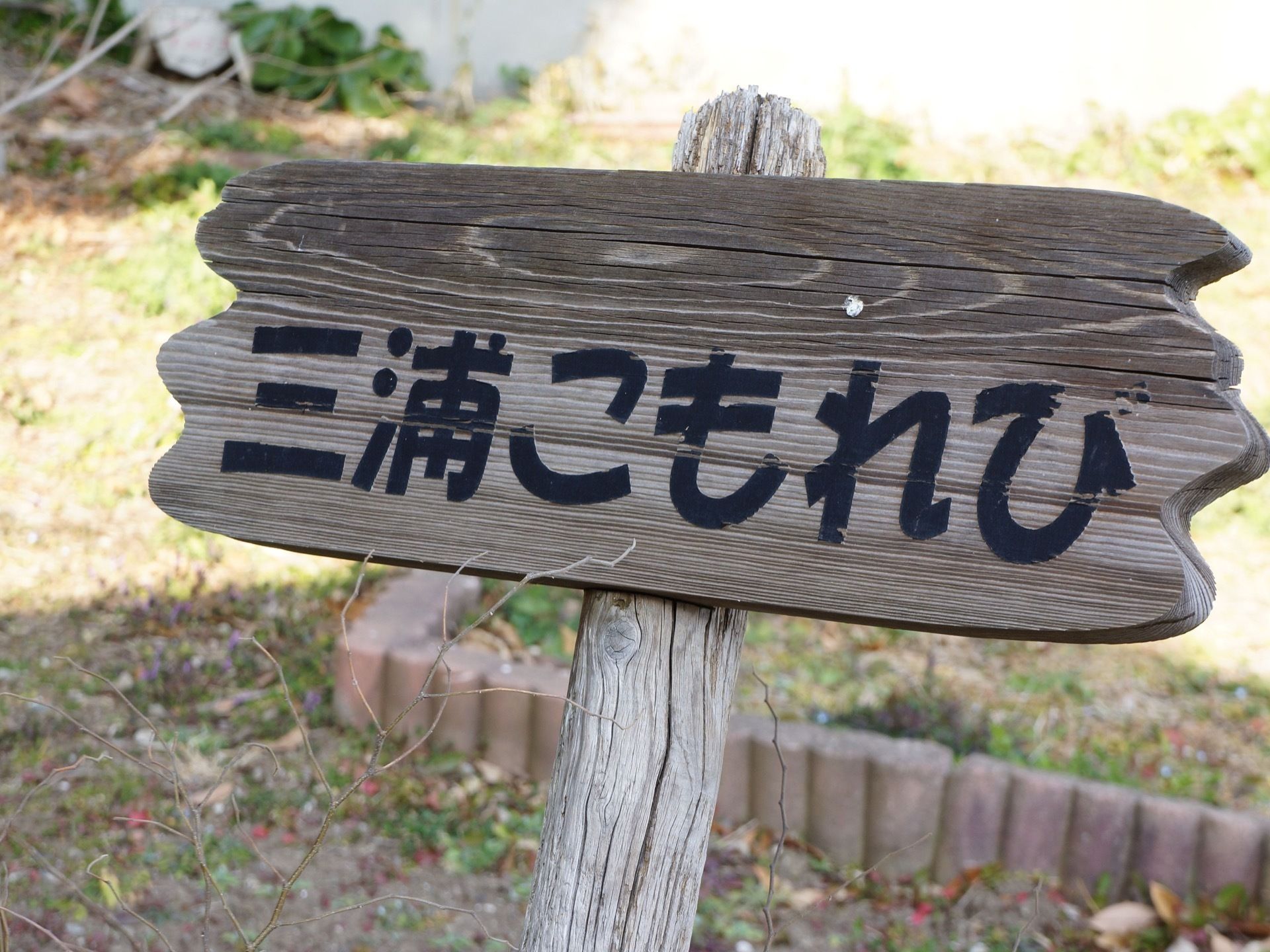 木製の看板に、分かりやすい大きな文字で施設名が書かれている。手作りのような、あたたかさを感じられる。