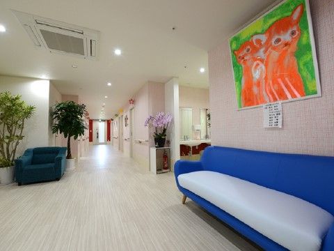 大きな絵画が飾られ、青い長ソファーが置かれた広い通路