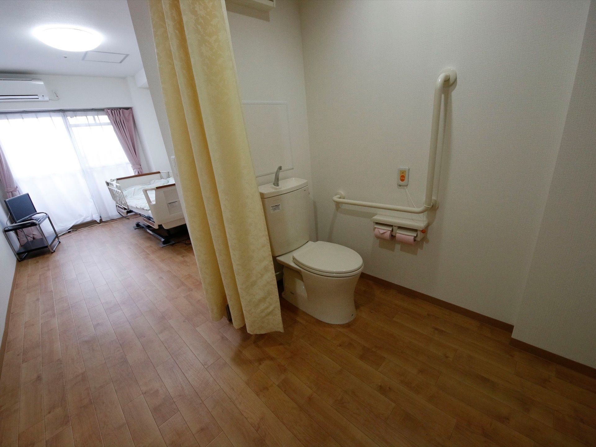 トイレには大きなカーテンがあり、個人のスペースを確保することができる。また、何か起きたときのための緊急呼出しボタンも設置されている。