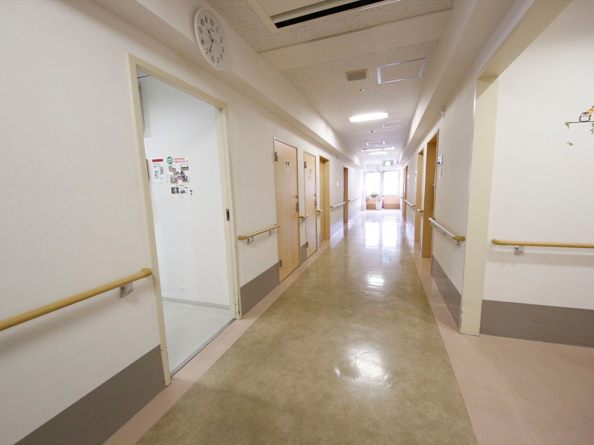 廊下は見通しもよく手すりが設置されている。モノクロ基調の落ち着いた雰囲気で入居者様はゆったりと生活することができる。