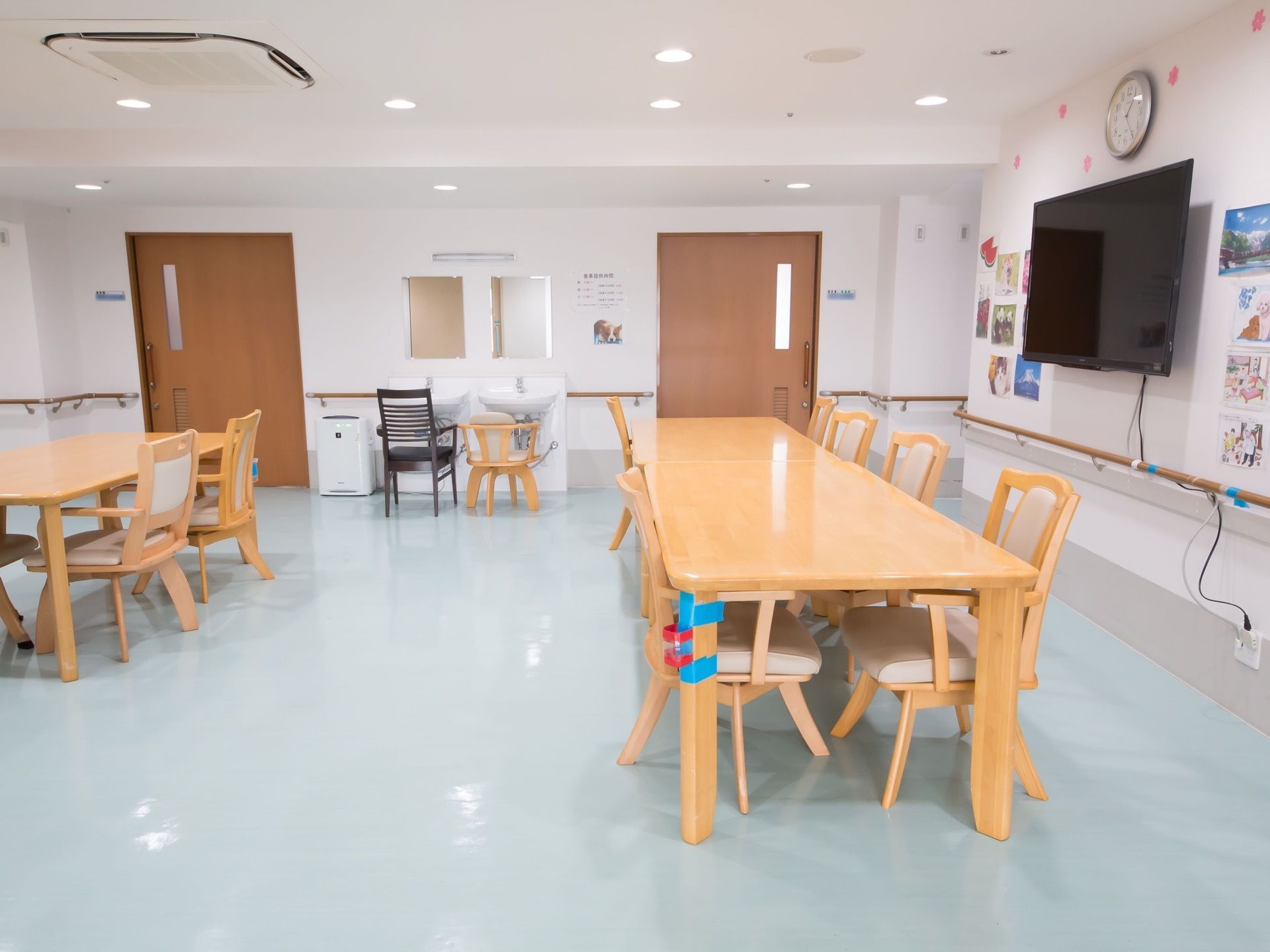 手洗い場が2か所あり、それぞれ椅子が置いてある。壁には、時計と大型テレビの他にも、写真が飾られている。